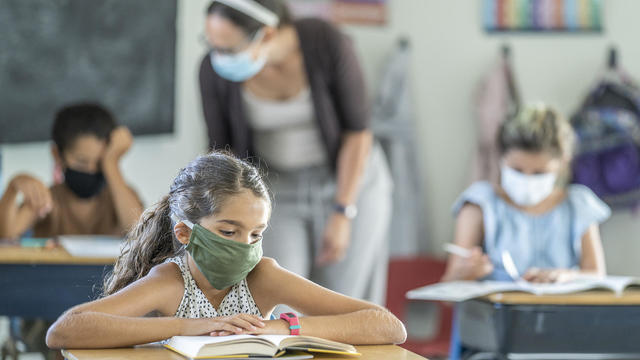 Young female student wearing a protective face mask in the classroom 