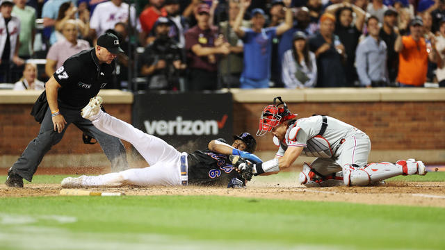 Starling Marte #6 of the New York Mets is tagged by J.T. Realmuto #10 of the Philadelphia Phillies as he slides into home during the ninth inning at Citi Field on August 12, 2022 in the Queens borough of New York City. 