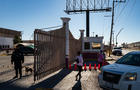 People at a gate of the Leona Vicario migrant shelter in Mexico 
