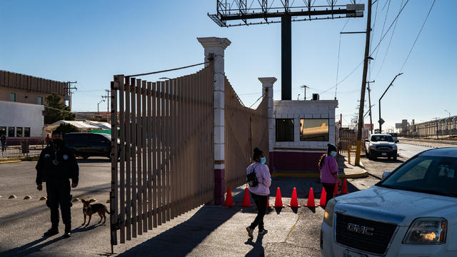 People at a gate of the Leona Vicario migrant shelter in Mexico 
