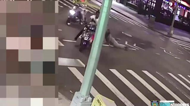 Surveillance photo of two suspects on scooters. Another man is hanging on to one of the scooters, being dragged on the road. 