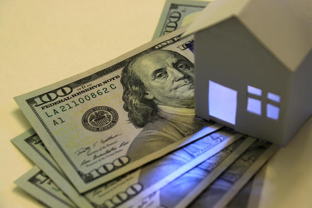 American hundred-dollar bills and illuminated paper house 