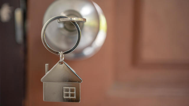 Silver house key in a door 