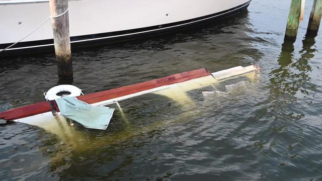 Part of a sunken boat is visible in a canal. 