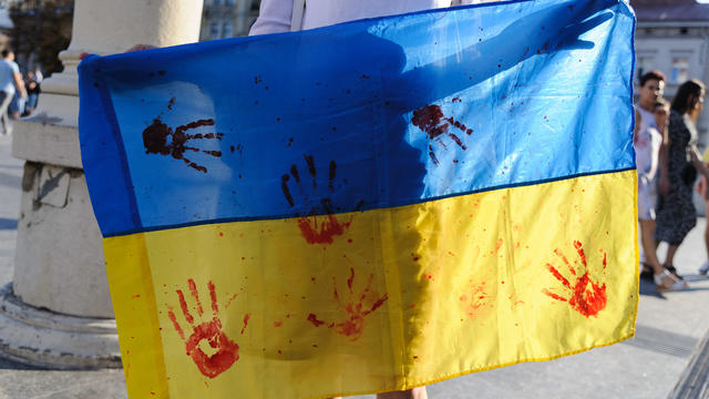 A protester holds a Ukrainian flag at a rally with a call to 