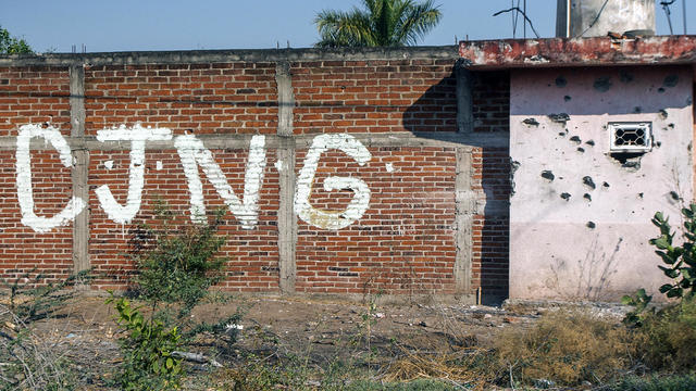 A bullet-riddled wall bearing the initials of the criminal group Cartel Jalisco Nueva Generacion (CJNG) is seen at the entrance of the community of Aguililla in the state of Michoacan, Mexico, on April 23, 2021. 