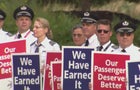 Line of pilots in uniform holding signs 