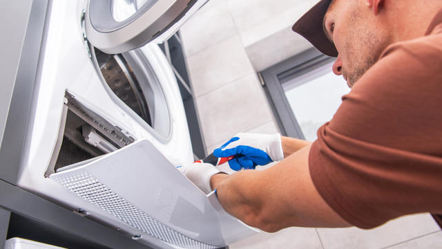 Repairman Fixing Washing Machine 