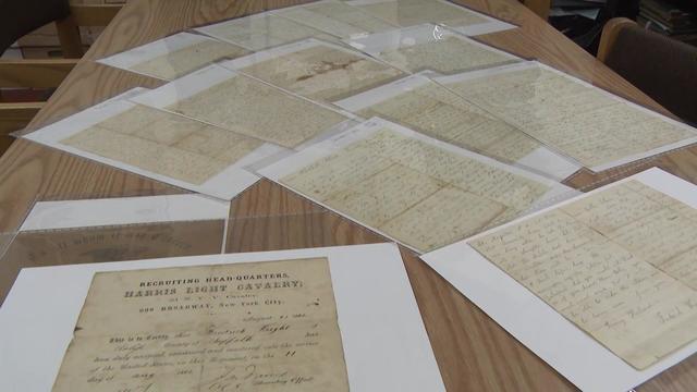 Preserved handwritten letters lay across a table. 