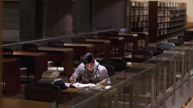 Student working in library at night 