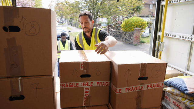 delivery men unloading boxes from van 