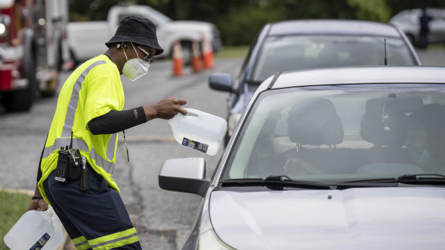 Workers with the Baltimore City Department of Public Works distribute jugs of water to city residents at the Landsdowne Branch of the Baltimore County Library on Sept. 6, 2022, in Baltimore, Maryland. 