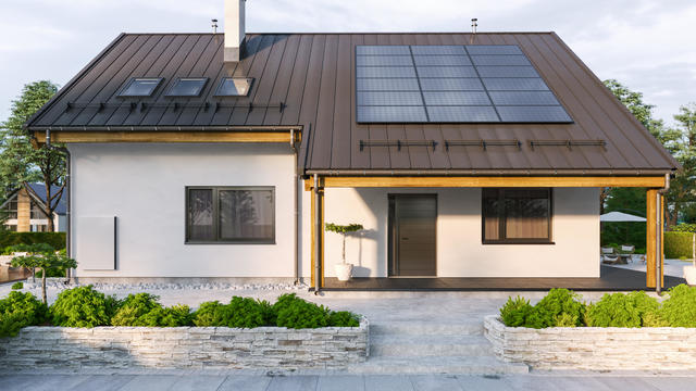 Modern House With Solar Panels And Wall Battery For Energy Storage 