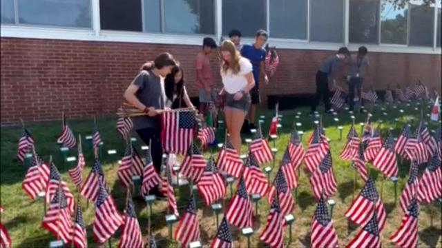 Cedar Grove High School students line the lawn with small American flags to honor the victims of 9/11. 