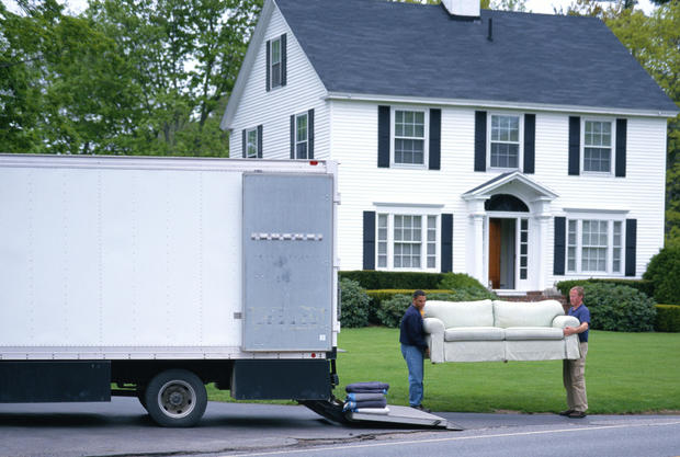 MOVING MEN UNLOAD FURNITURE FROM TRUCK 