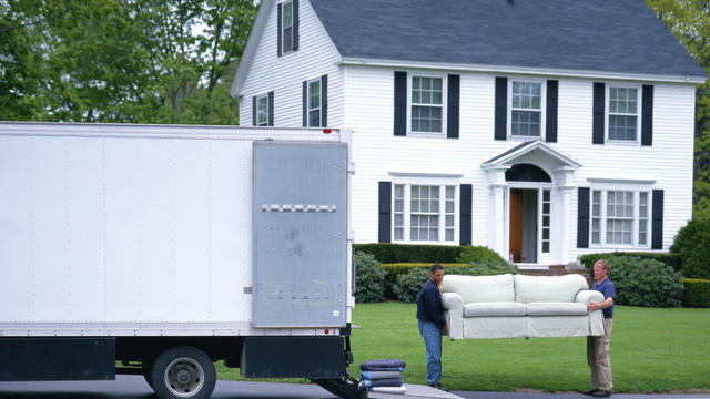 MOVING MEN UNLOAD FURNITURE FROM TRUCK 