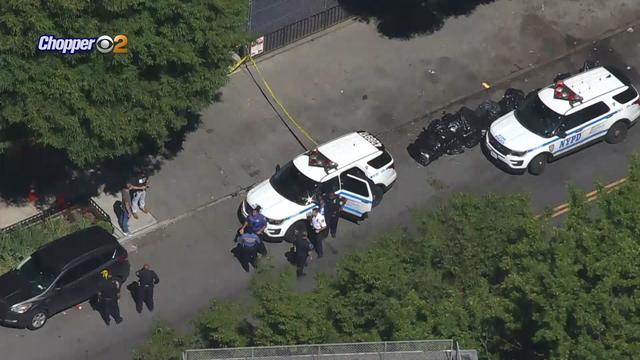 An aerial shot of NYPD vehicles parked on a street that has been partially blocked off with crime scene tape. 