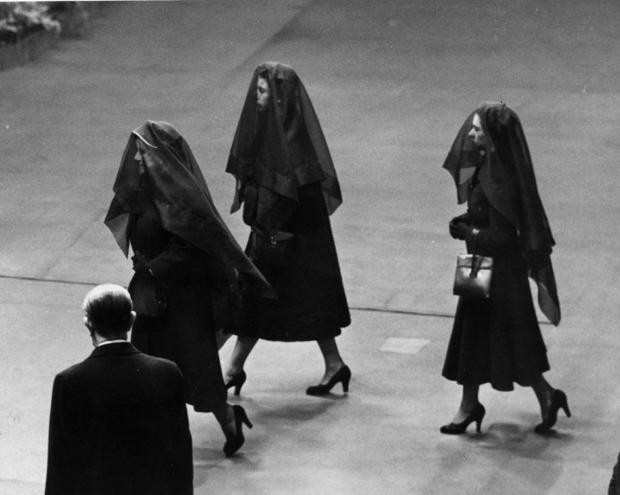 Queen Elizabeth II; her mother, Queen Elizabeth the Queen Mother; and her sister, Princess Margaret, attend the arrival of the coffin of King George VI at Westminster Hall, London, Feb. 11, 1952. 