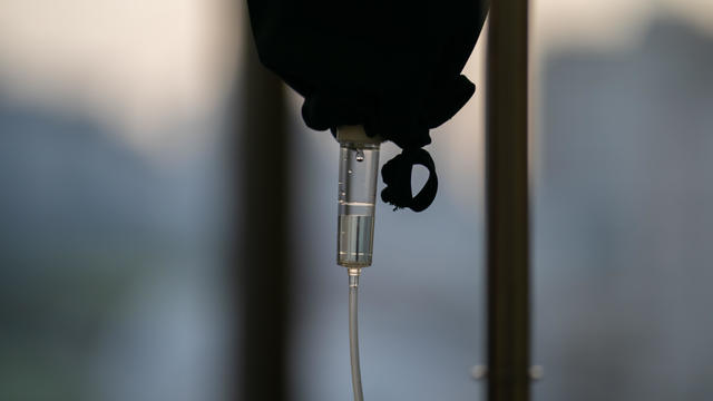 close up to the medical tool, saline drip in the dark silhouette theme on the evening window light. 