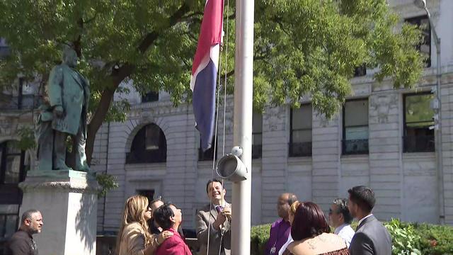 Mayor Andre Sayegh and other officials raise the Dominican flag outside Paterson City Hall. 