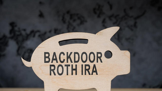Wooden piggy bank with words backdoor Roth IRA. 
