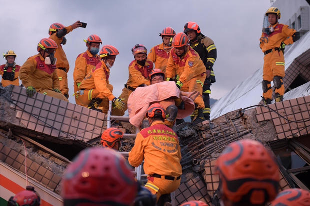 In this photo provided by Hualien City Government, a victim is carried by firefighter during a rescue operation following an earthquake in Yuli township, Hualien County, eastern Taiwan on Sunday