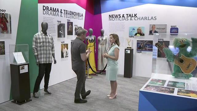 CBS2's Dave Carlin stands with Mercedes Anderson, director of communications for the Paley Center for Media, in the center's Hispanic Achievements in Television exhibition. 