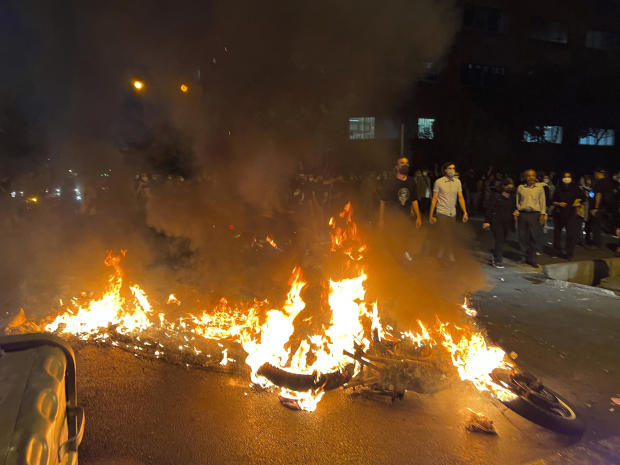 A photo taken by an individual not employed by the Associated Press and obtained by the AP outside Iran shows a police motorcycle burning during a protest over the death of a young woman who had been detained for violating the country's conservative dress code