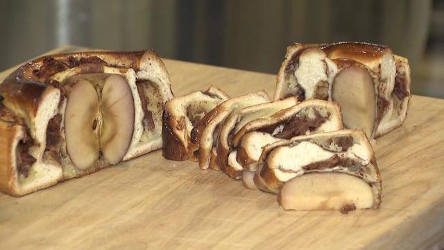 A loaf of round challah with a whole baked apple inside. 