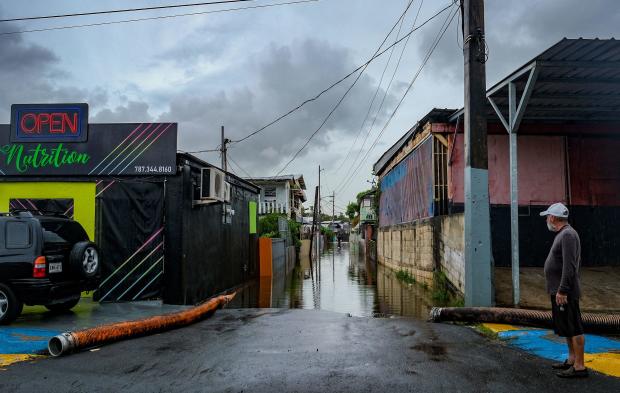A man looks at a flooded street in the Juana Matos neighborhood of Catano, Puerto Rico, on September 19, 2022, after the passage of Hurricane Fiona. 