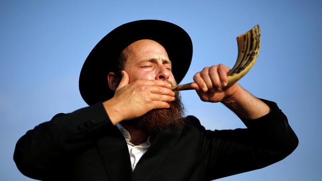 An ultra-Orthodox Jewish man blows a shofar, before he takes part in prayer a Tashlich prayer 
