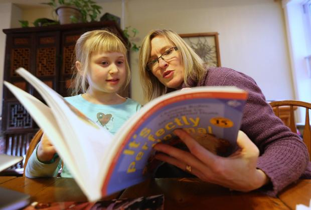A Mother Reads A Book About Puberty To Her Daughter 