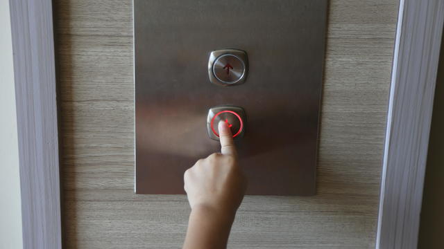Cropped Hand Of Girl Pressing Elevator Button 