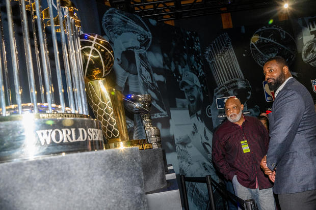 Cecil Fielder and Chris Canty look at Championship trophies at PaleyWKND outside the Paley Museum on October 01, 2022 in New York City. 