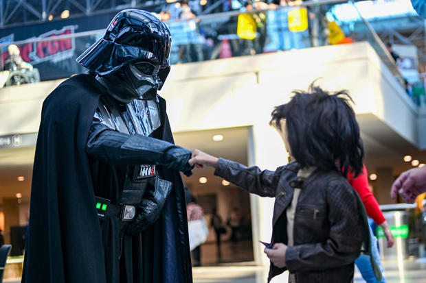 A Darth Vader cosplayer fist bumps a Han Solo cosplayer during New York Comic Con 2022 on October 06, 2022 in New York City. 