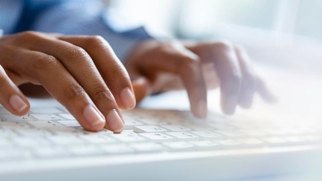 Hands of young woman typing on computer keyboard 