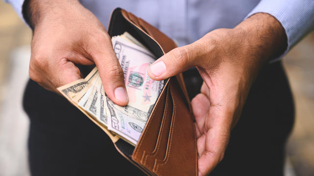 Close up Business man counting the money spread of cash in wallet. 