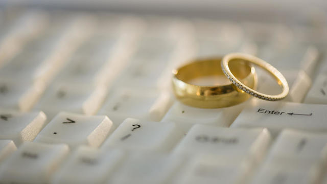 Close up of wedding rings on computer keyboard 