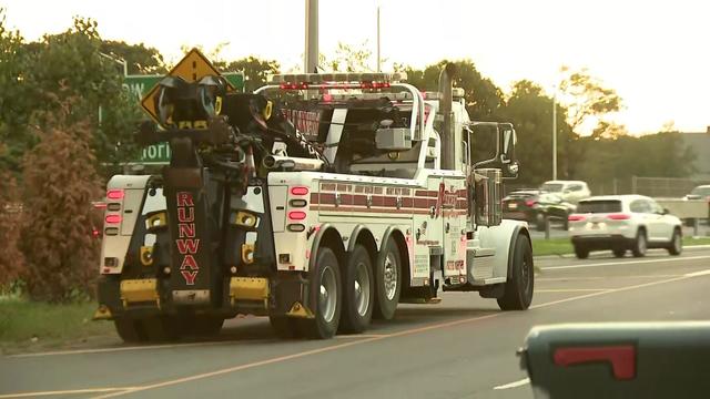 A Runway Towing vehicle on a highway. 