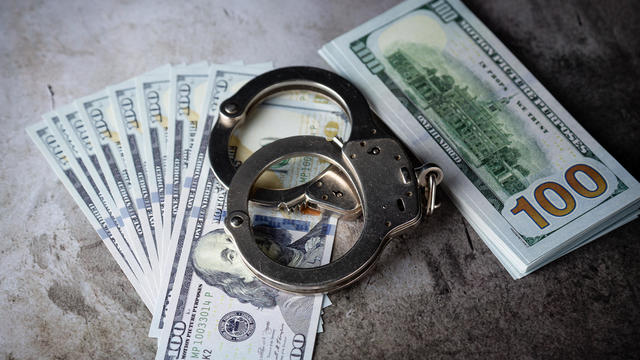 Handcuffs on $100 Bills on Concrete Floor for Crime or DUI 