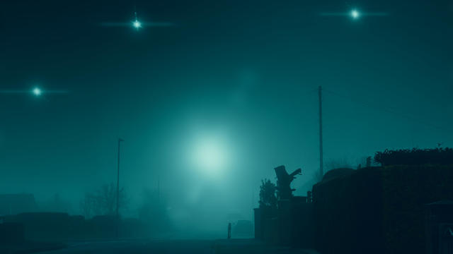 Glowing UFO lights in the sky. In a quiet empty road in a suburban town. On a quiet, atmospheric foggy winters day. UK 