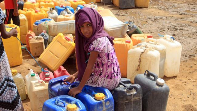 A Yemeni girl waits as others fill their jerrycans with water at a makeshift camp for the internally displaced, in the northern Hajjah province on June 4, 2022, amid a severe heat wave and acute water shortage. 