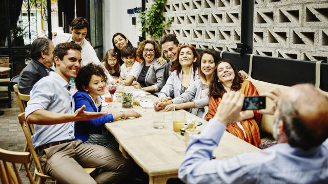 Man taking family portrait in restaurant 