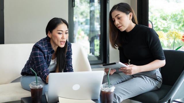 ํYoung Asian women having discussion with female financial consultant insurance agency in coffee shop 