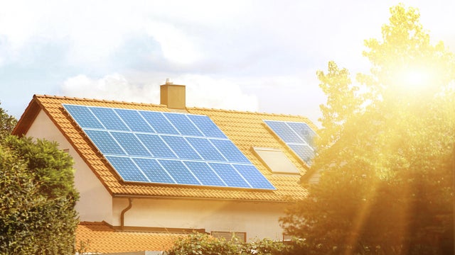 Solar panels on the tiled roof of the building in the sun. 
