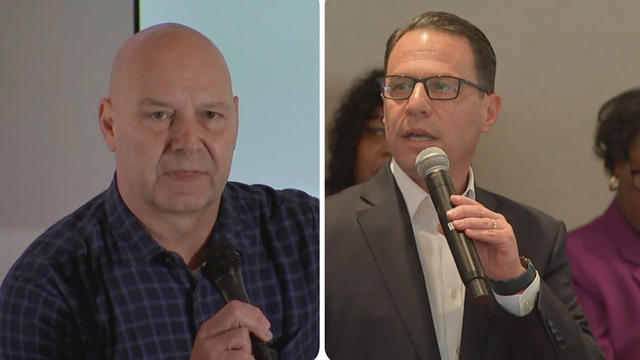 Doug Mastriano holding microphone at event. he is wearing a striped shirt. Josh Shapiro is also in the image holding a microphone at a campaign event. He is wearing a suit jacket and button up shirt and eyeglasses. 