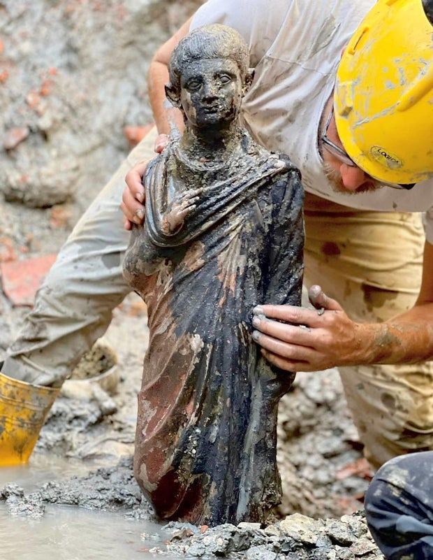 A bronze sculpture depicting someone in a robe 