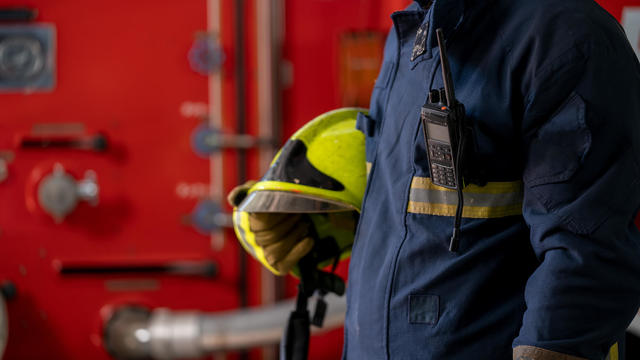 Fireman wearing uniform and helmet at fire station. 