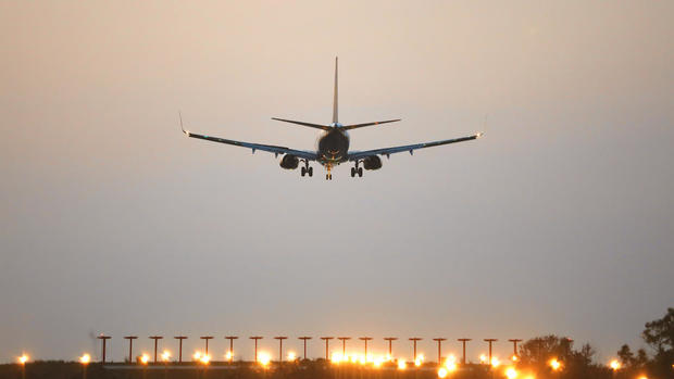 Commercial airplane approaching the runway for landing during sunset 