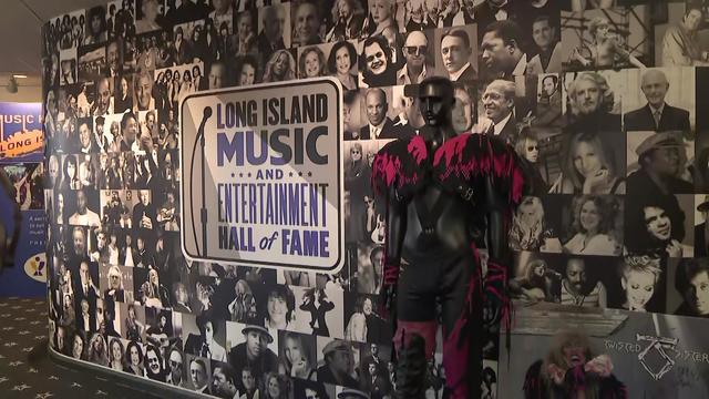 A part of the Long Island Music and Entertainment Hall of Fame features the museum's logo on a wall surrounded by black-and-white pictures of Long Island entertainers. A costume Dee Snider wore on the cover of an album is on display. 